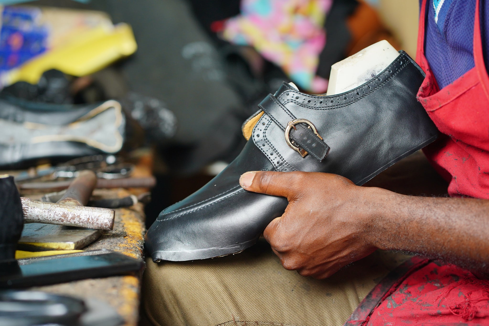 A May Anthony craftsperson handmaking a velvet loafer in our Lagos workshop